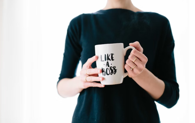 A woman holding a mug with a catchphrase