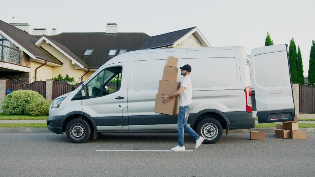  a delivery man carrying boxes outside of a delivery van