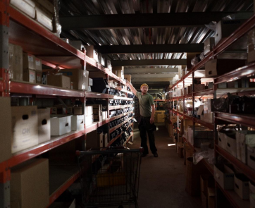 A man in a green t-shirt working in a warehouse