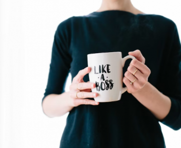 A woman holding a mug with a catchphrase